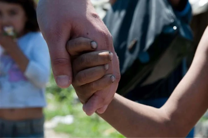 Ein Kind hält die Hand eines Erwachsenen