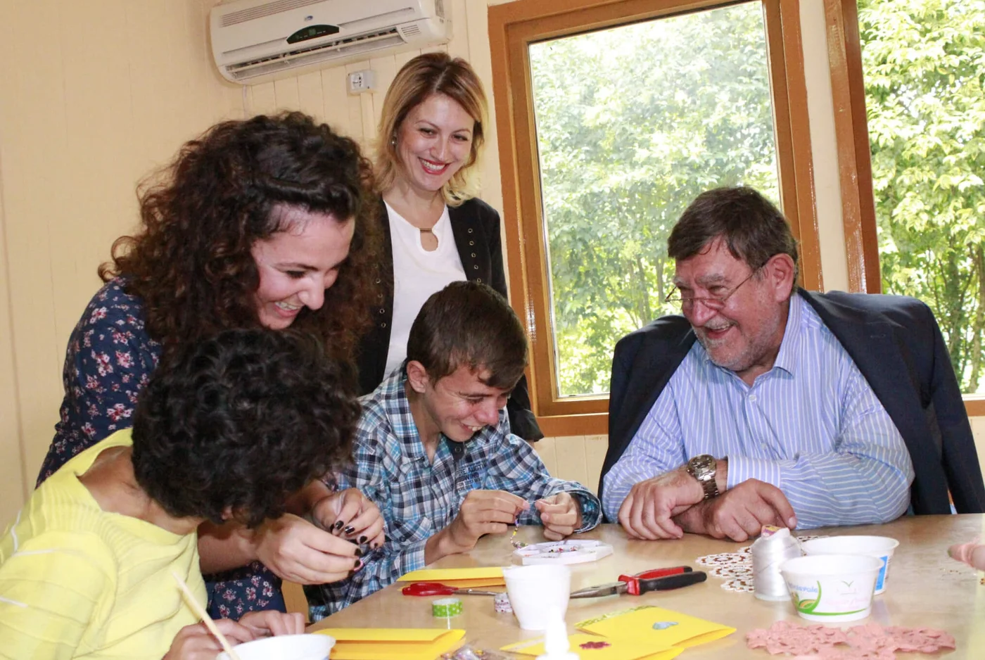 Individuals gather around a table, enjoying a crafting session facilitated by Stepic Charity CEE.