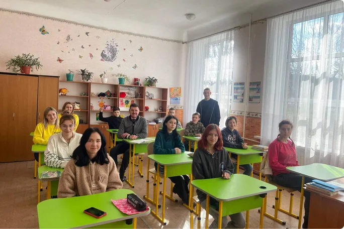 Eine vielfältige Gruppe von Schülern, die im Klassenzimmer an Schreibtischen lernt, Stepic Charity CEE hilft und bildet Kinder aus.
