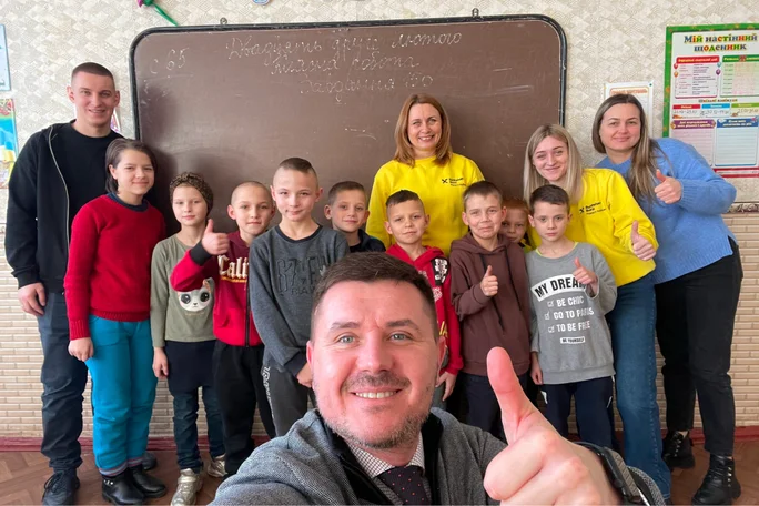 Eine Gruppe von Kindern und ein Mann posieren glücklich mit Unterstützung von Stepic CEE Charity für ukrainische Kinder.