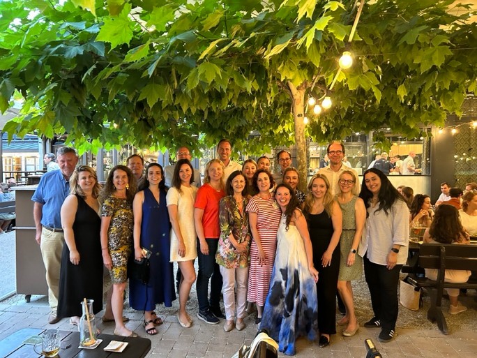 Gruppe von Menschen, die im Gras lächeln und posieren